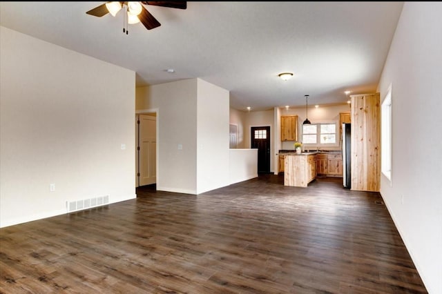 unfurnished living room with ceiling fan and dark hardwood / wood-style flooring