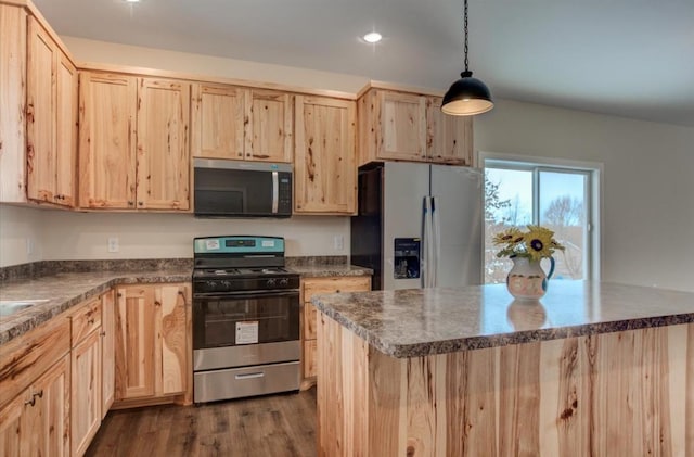 kitchen with hanging light fixtures, light brown cabinets, and appliances with stainless steel finishes