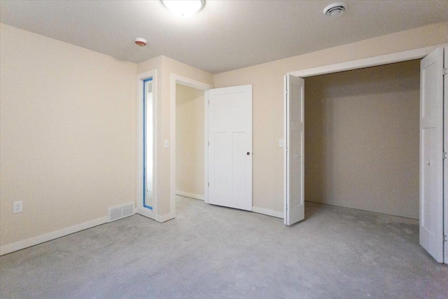 unfurnished bedroom featuring light carpet and a closet