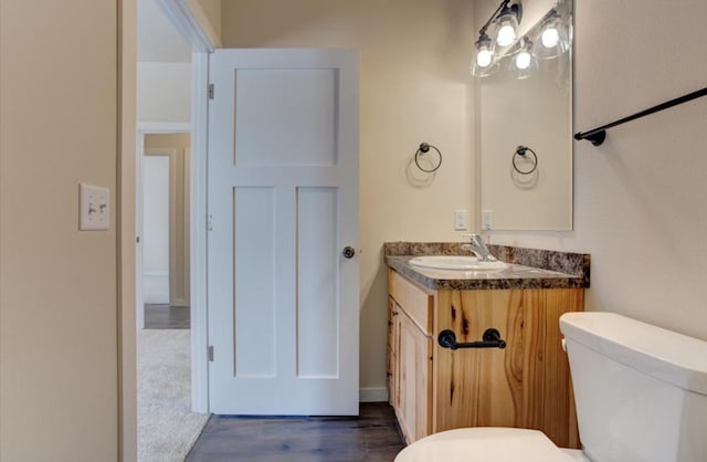 bathroom with vanity, toilet, and wood-type flooring