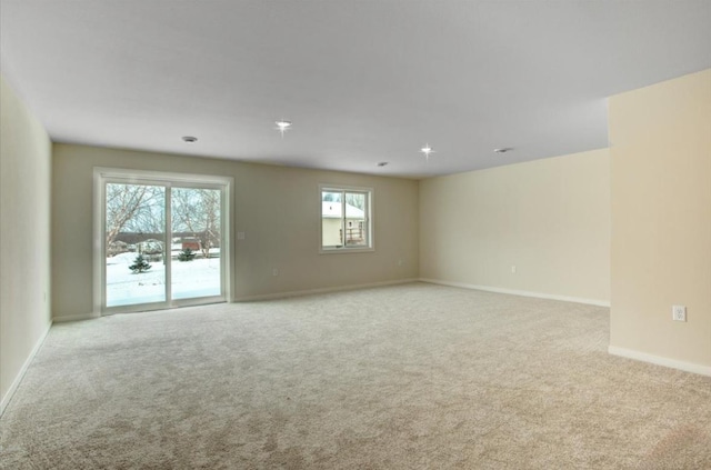 spare room featuring light carpet and plenty of natural light