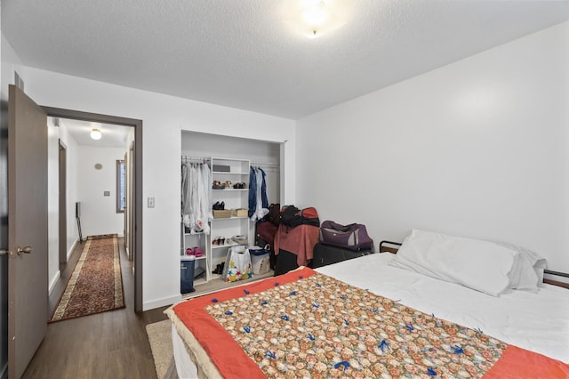 bedroom featuring a closet, a textured ceiling, and dark hardwood / wood-style flooring