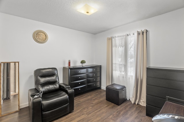 sitting room featuring a textured ceiling and dark hardwood / wood-style floors