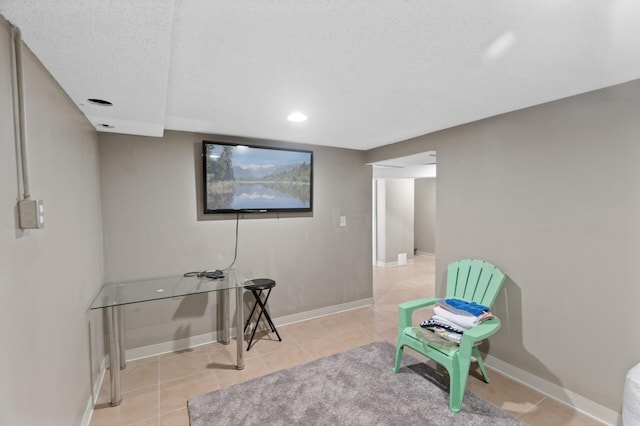 sitting room featuring a textured ceiling and light tile patterned flooring