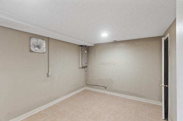 basement with a textured ceiling and light tile patterned floors