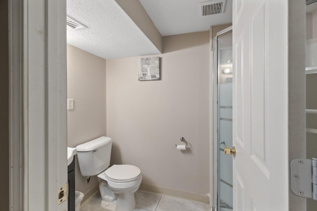 bathroom featuring a textured ceiling, toilet, and tile patterned flooring