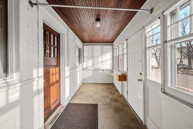 unfurnished sunroom featuring a barn door and wooden ceiling