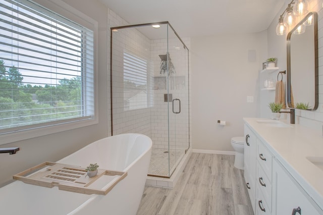 full bathroom featuring vanity, hardwood / wood-style floors, independent shower and bath, and toilet