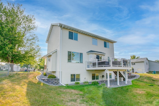 back of property featuring a wooden deck and a lawn