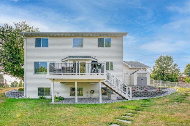 back of house with a storage shed, a lawn, and a deck