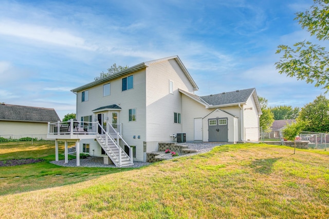 rear view of house with central AC unit, a lawn, a deck, and a storage shed