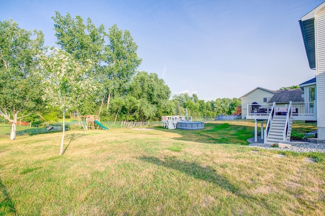 view of yard featuring a pool side deck and a playground