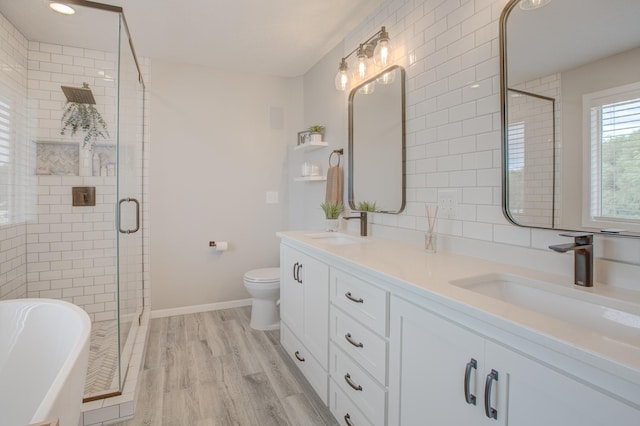 full bathroom featuring hardwood / wood-style flooring, vanity, shower with separate bathtub, and toilet