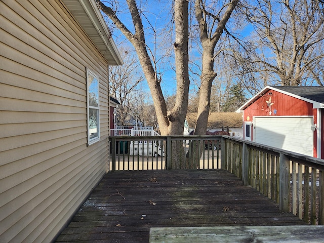 wooden deck featuring a garage and an outdoor structure