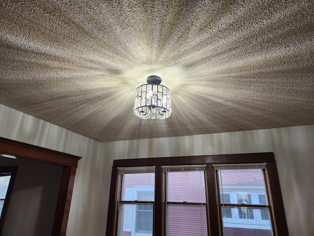 room details featuring a textured ceiling and a notable chandelier