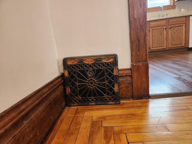 room details featuring sink, white dishwasher, and hardwood / wood-style flooring