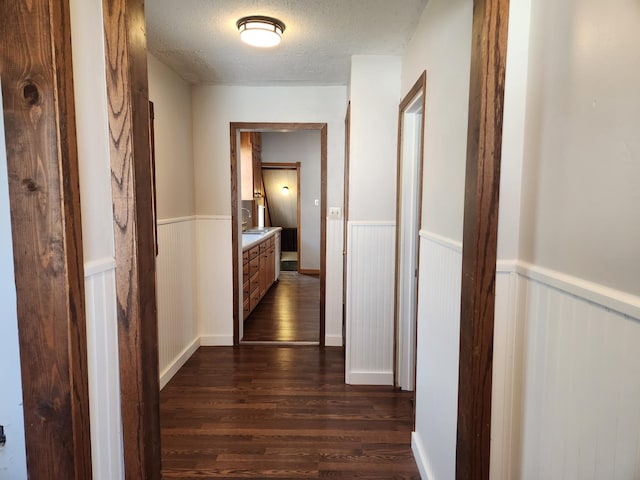 corridor featuring dark hardwood / wood-style flooring and a textured ceiling