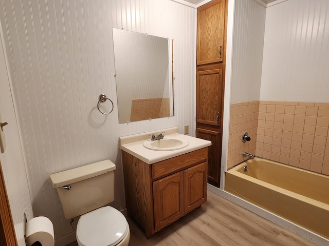 bathroom featuring hardwood / wood-style floors, a washtub, toilet, and vanity