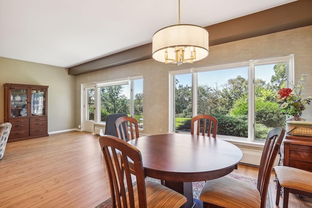 dining area with light wood-type flooring and a chandelier