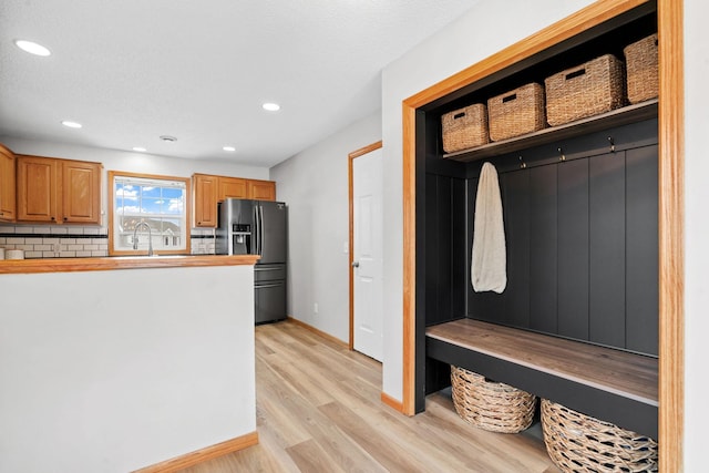 mudroom featuring sink and light hardwood / wood-style floors