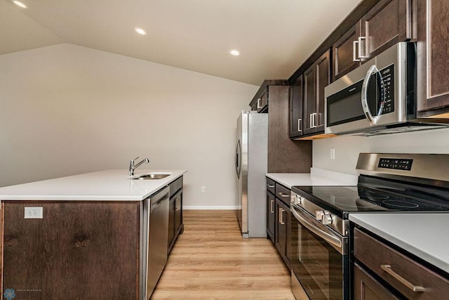 kitchen featuring stainless steel appliances, lofted ceiling, dark brown cabinets, and sink