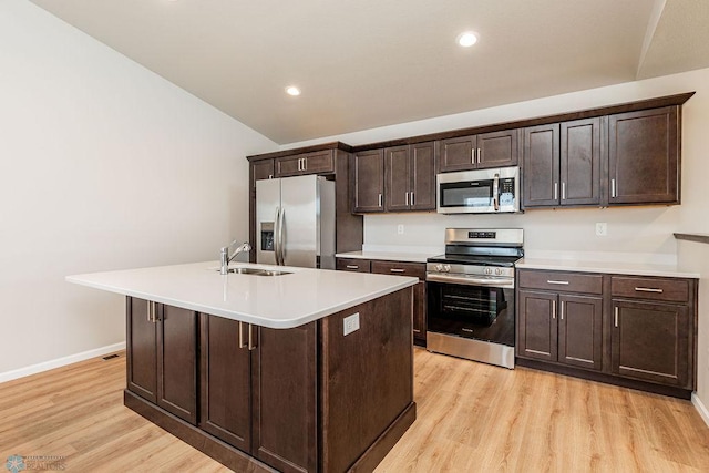 kitchen featuring sink, dark brown cabinetry, appliances with stainless steel finishes, and a center island with sink