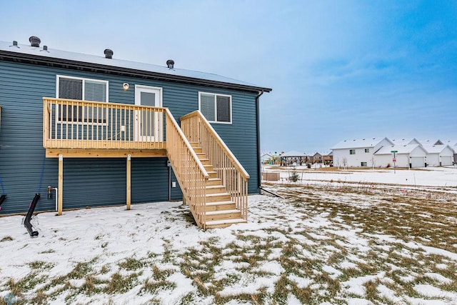 snow covered house featuring a wooden deck