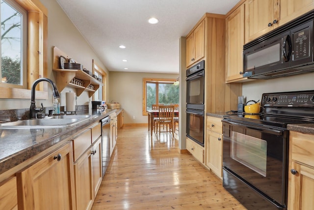 kitchen with light brown cabinets, sink, light hardwood / wood-style floors, and black appliances