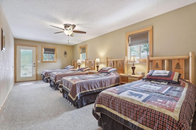 carpeted bedroom featuring ceiling fan and a textured ceiling