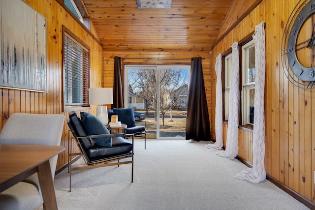 living area with lofted ceiling, wooden ceiling, carpet flooring, and wood walls