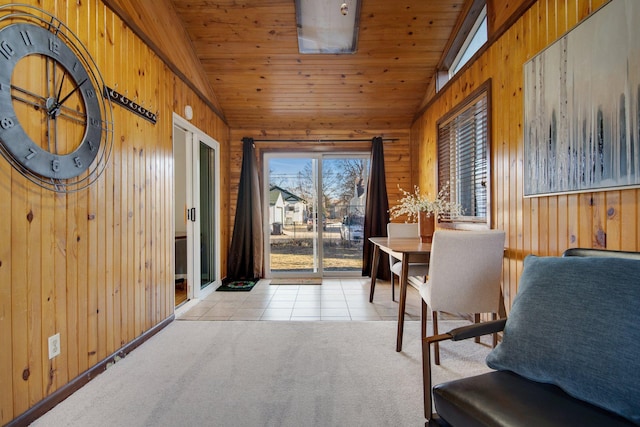 entryway with carpet, wood ceiling, tile patterned flooring, and wooden walls