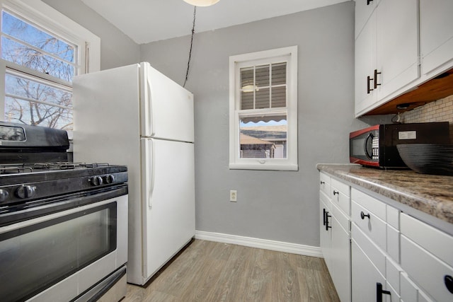 kitchen featuring tasteful backsplash, stainless steel gas stove, light wood-type flooring, black microwave, and baseboards