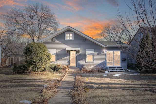 bungalow-style house with entry steps and fence