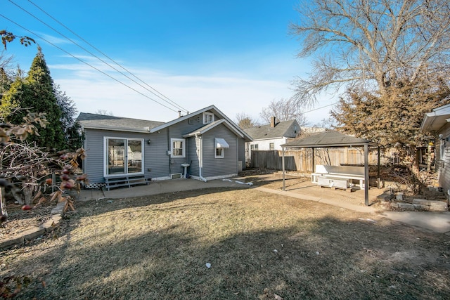 rear view of property with a patio, a lawn, a gazebo, entry steps, and fence