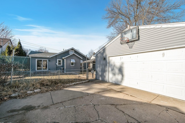 view of front of home featuring a garage, an outbuilding, and fence