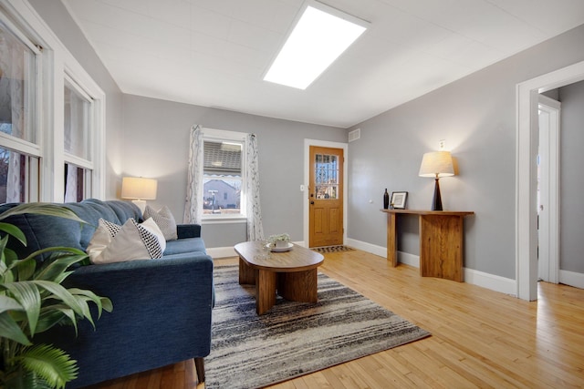 living area with light wood-type flooring and baseboards