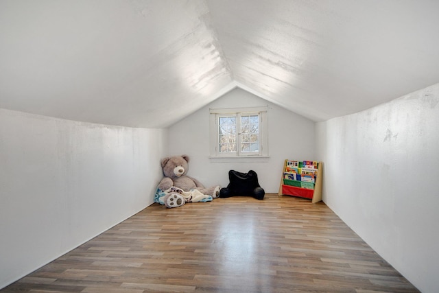 bonus room with wood finished floors and vaulted ceiling
