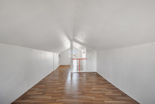 additional living space with wood finished floors and vaulted ceiling