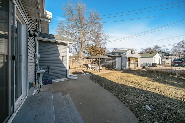 view of yard with fence, a patio area, a residential view, and an outdoor structure