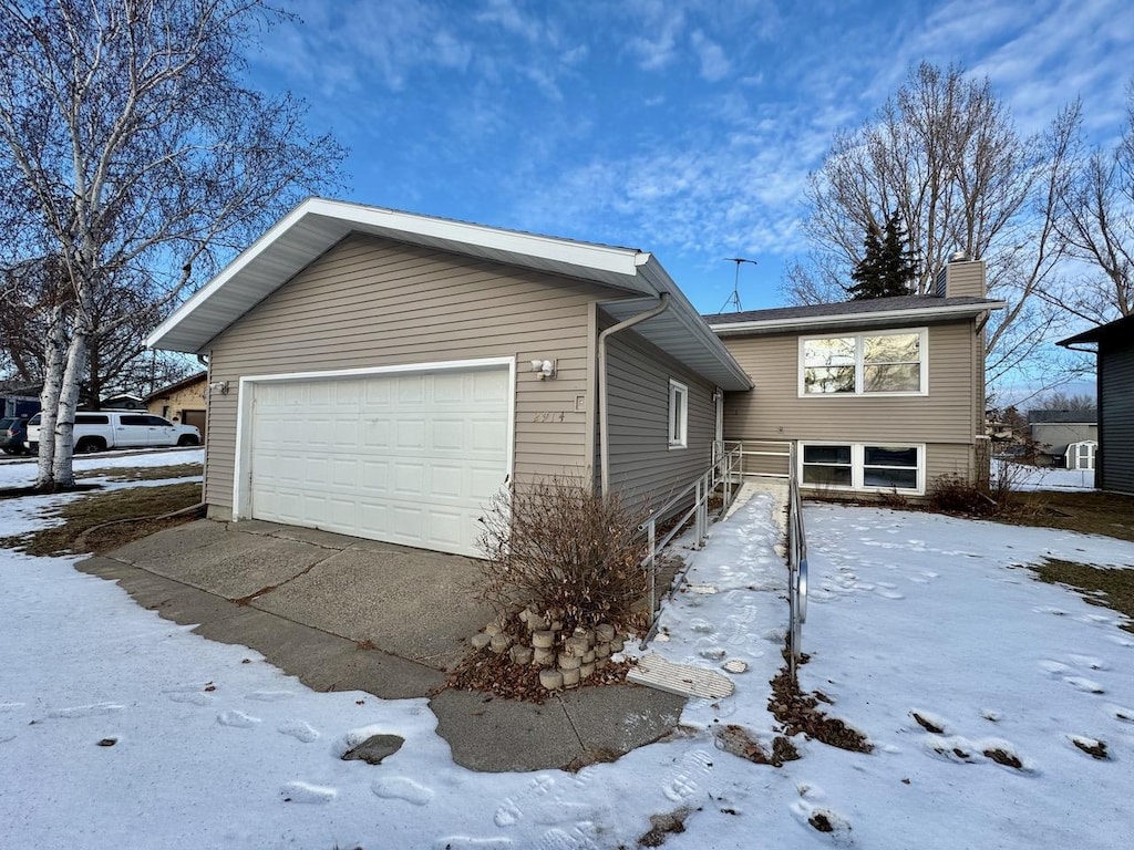 view of snow covered exterior with a garage