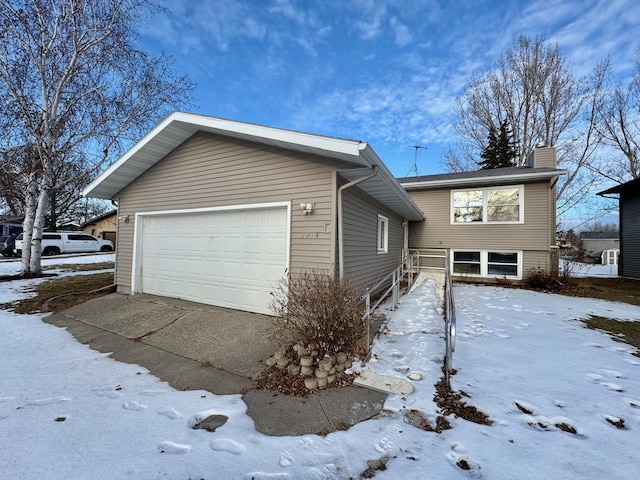 view of snow covered exterior with a garage