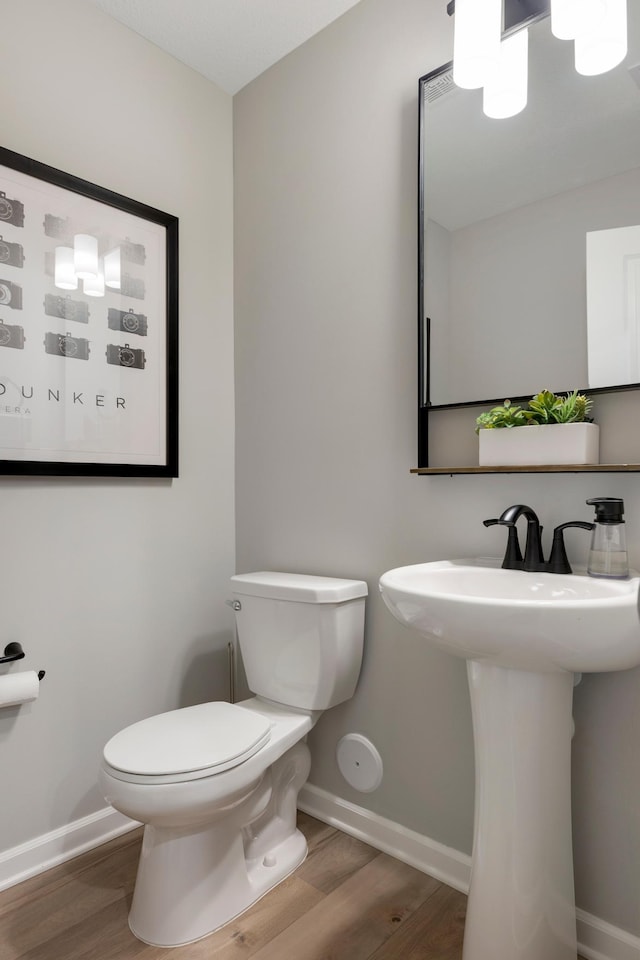 bathroom with sink, hardwood / wood-style floors, and toilet