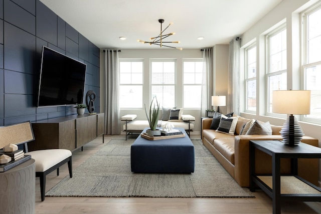 living room with light wood-type flooring and a chandelier