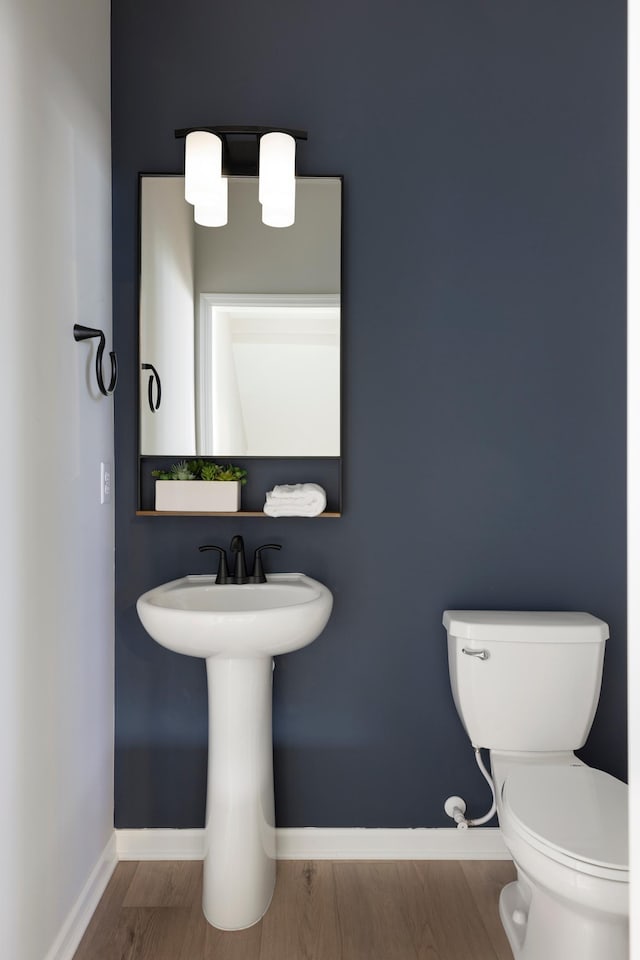 bathroom featuring wood-type flooring and toilet