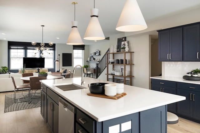 kitchen with a center island with sink, stainless steel dishwasher, and sink