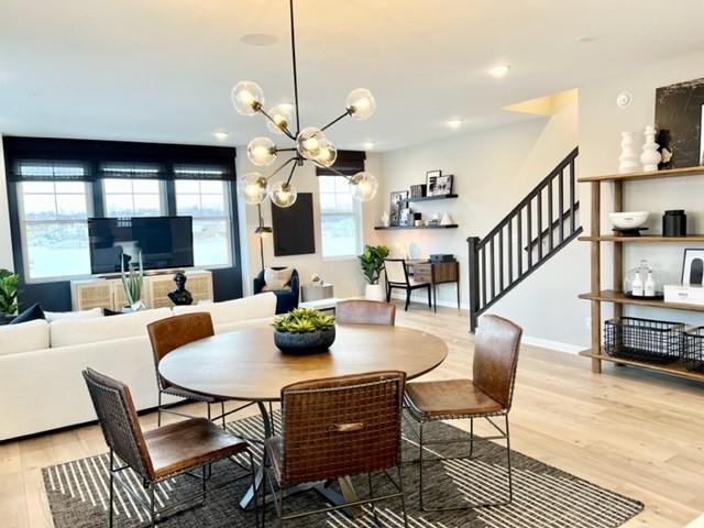 dining space with light wood-type flooring and a chandelier