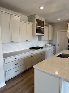 kitchen featuring sink, a kitchen island, dark wood-type flooring, and stainless steel gas cooktop