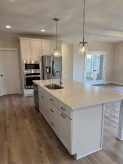 kitchen featuring a center island with sink, white cabinets, sink, and appliances with stainless steel finishes