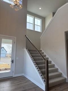 foyer featuring dark hardwood / wood-style flooring, a chandelier, and a high ceiling