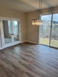 unfurnished dining area with plenty of natural light, dark hardwood / wood-style floors, and french doors